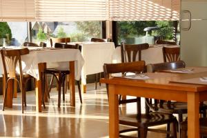 维耶拉Hotel Blu Aran的用餐室设有桌椅和窗户。
