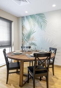 艾恩New fully serviced 1BR Apartment的一间带木桌和椅子的用餐室
