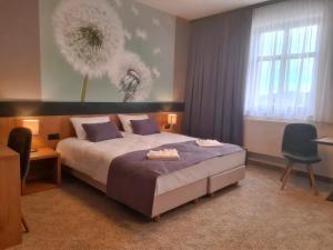 托日姆HOTEL PORT 2000 Torzym的一间卧室配有一张床、一张书桌和一个窗户。