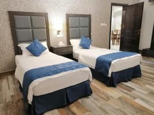 达曼مساس الخليج Mesas Gulf وحدات سكنية的酒店客房 - 带两张带蓝色枕头的床