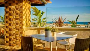 科尼尔-德拉弗龙特拉Hostal Campito的露台配有桌椅,享有海滩美景