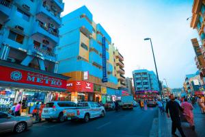 迪拜AL KARNAK HOTEL - BRANCH的一条繁忙的城市街道,街道上有很多汽车和人,建筑