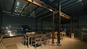 马尼拉RedDoorz Premium @ West Avenue Quezon City的屋顶上带桌椅的天井