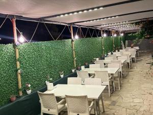费特希耶garden alis hotel的一排桌子和椅子,墙上绿着绿色的墙