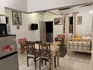 拉穆Beytsalaam Apartments的厨房以及带桌椅的起居室。