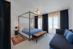 纳乌萨Kallisti Paros的一间卧室配有天蓬床和沙发