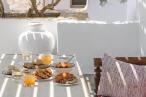 纳乌萨Kallisti Paros的餐桌,带食物盘和橙汁杯