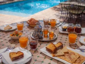 El HarkatVilla Katia的餐桌,带食物盘和橙汁杯