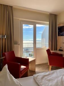 萨斯尼茨Rügen-Hotel的酒店客房设有一张床和一个享有美景的窗户。