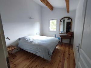 博迪昂Maison Couquets Bauduen的卧室配有白色的床和镜子