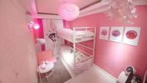 首尔Spring Light的粉红色的客房设有双层床和椅子