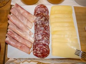 罗马B&B JONIO Roma的桌上放有香肠和奶酪的盘子