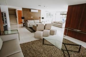 弗洛里亚诺波利斯卡纳斯维尔莱斯海酒店的客厅配有白色家具和玻璃桌