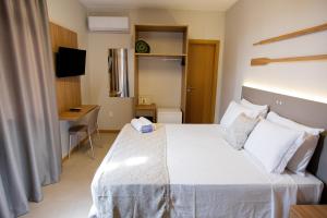 弗洛里亚诺波利斯卡纳斯维尔莱斯海酒店的一间卧室配有一张床、一张书桌和一台电视