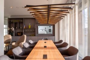 凯沃拉尔elaya hotel kevelaer的一间会议室,配有木桌和椅子