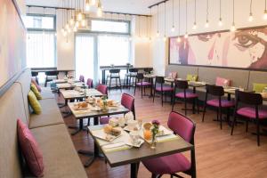 日内瓦蒙塔纳酒店的用餐室配有桌子和粉红色的椅子