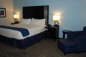 史普林维尔Holiday Inn Express & Suites Springville-South Provo Area, an IHG Hotel的酒店客房,配有一张床和一张蓝色椅子