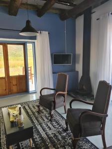 蒙塔古Harmonie Farm Cottages的客厅配有两把椅子、一张桌子和一台电视