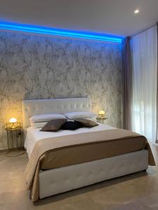 布林迪西b&b THE WORLD的一间卧室配有一张白色大床,拥有蓝色的灯光