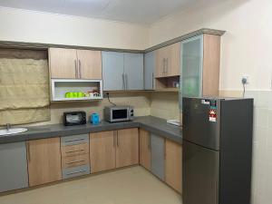 史里肯邦安D’Lestari Homestay的厨房配有冰箱和微波炉。