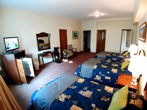利马Hotel MAURY的酒店客房设有两张床和电视。