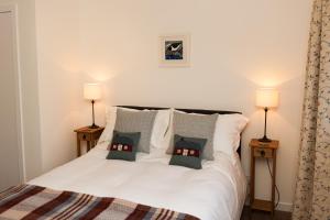 HallinAn Cala Beag Self Catering apartment on The Waternish Peninsula的卧室配有带两盏灯的白色床