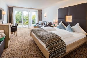 沃尔特湖畔佩莎赫Seehotel Das JO的酒店客房设有一张大床和一间客厅。