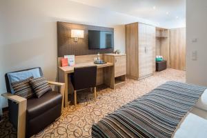 沃尔特湖畔佩莎赫Seehotel Das JO的酒店客房设有一间带书桌和床的卧室
