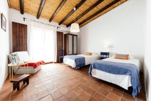 Vila Verde de FicalhoAgroturismo Flores do Campo的一间卧室配有两张床,卧室内配有沙发