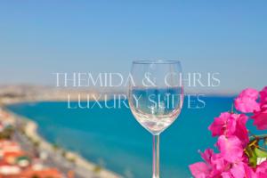 拉纳卡Luxury Penthouse 1BR-Seafront-Seasonal Pool-Central的一杯葡萄酒,旁边是一些粉红色的花