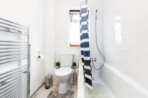 GoodmayesCosy 2 bedroom house! Dagenham! Free parking的白色的浴室设有卫生间和淋浴。