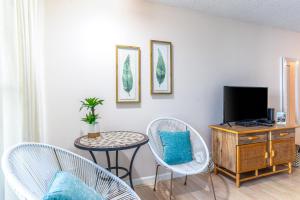 科纳Kona Islander Inn 112的客厅配有电视和桌椅