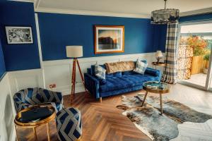 纽卡斯尔The Hikers House的客厅拥有蓝色的墙壁和蓝色的沙发