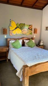 卡皮托利乌Pousada Fecho da Serra的卧室配有一张床上,墙上挂着蝴蝶