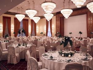 约阿尼纳杜拉克会议水疗中心酒店 的宴会厅配有白色的桌椅和吊灯