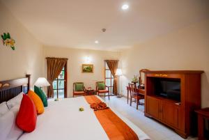 芭东海滩Phuket Leelavadee Hua Ting Resort的一间卧室配有一张大床和电视