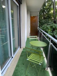 克莱蒙费朗L’Oradou - Neuf - Tout équipé - Parking - Wifi的阳台的绿色桌椅