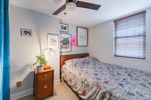 费城Bedroom in thoughtfully decorated East Passyunk home (South Philadelphia)的一间卧室配有一张床、一个梳妆台和一扇窗户。