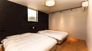 日光Rakuten STAY MOTEL Nikko Kinugawa Garage Concept Room的卧室设有两张床,拥有黑色的墙壁和窗户。