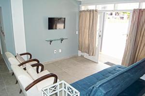 帕罗卡Casa com 2 quartos à 200 m da da praia c/ churrasqueira的客厅配有蓝色的沙发和椅子