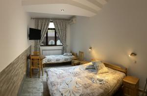 加布罗沃Guesthouse Hitar Petar的一间卧室配有两张床和一台平面电视