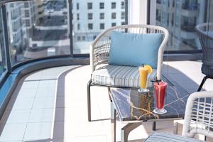 迪拜金沙公寓酒店的配有枕头的椅子和阳台桌子上的饮品