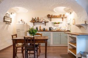 比耶拉B&b Il Cortile的厨房配有木桌、椅子和冰箱