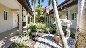 圣徒皮特海滩Palm Crest Resort Motel的棕榈树和植物的房子的门廊