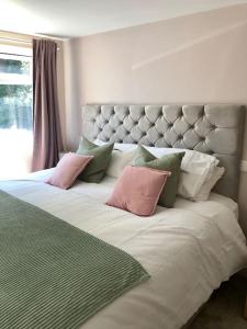 巴斯Quiet and cosy flat, close to Bath Centre的一张大床,上面有粉色和绿色的枕头