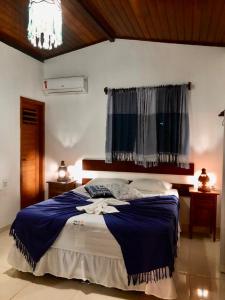 皮帕Fiquei In Pipa - Chalé 21的一间卧室配有一张带蓝色毯子的床和窗户。