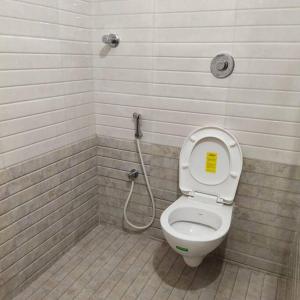 蓬蒂切里Sapphire Luxury Apartment的浴室设有卫生间,盖子上有一个黄色标志