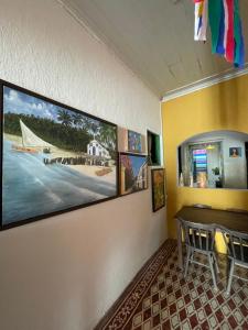 奥林达Canto dos Artistas Olinda的一间用餐室,配有一张桌子和一张墙上的照片