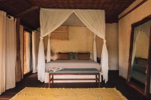 图卢姆Radhoo Tulum的一间卧室配有一张带天蓬的床