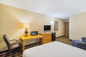 法戈Americas Best Value Inn Fargo的酒店客房配有一张床和一张书桌及一台电视